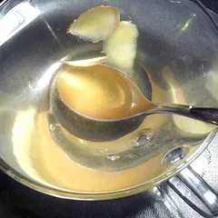 Ginger tea with fresh ginger slices and a spoon