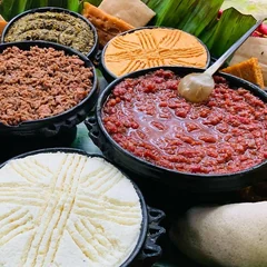 Kitfo in a clay bowl with ayib and injera