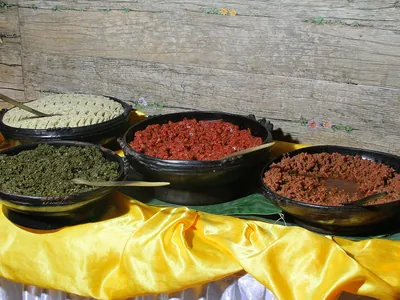A spread of kitfo, gomen and ayib in clay bowls