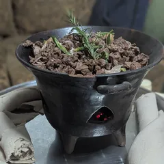Tibs: sautéed beef with rosemary in a clay pot, with rolled injera